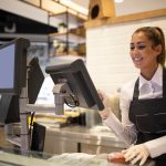 A girl infront of a cashier counter in a shop