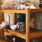 a woman rearranging things on her wooden display rack