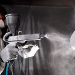 A guy using spray painting system