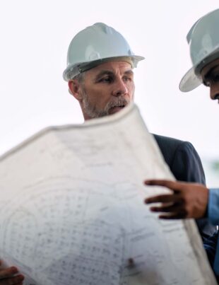 Engineering consultant visit construction site and discuss with senior engineer for progress of high rise building infrastructure